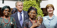 President George W. Bush and first lady Laura Bush greet local mothers affected by AIDS with their HIV-free children in the courtyard of the Abuja National Hospital and laboratory in Abuja, Nigeria, the last stop on his African tour, on July 12, 2003.