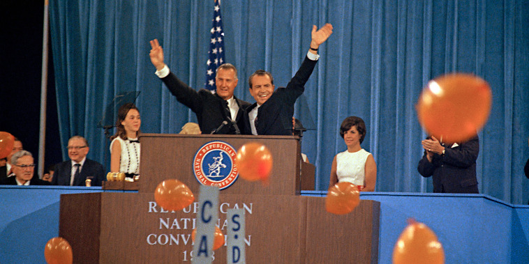 Republican presidential candidate Richard Nixon, waving right, and his running mate Spiro Agnew react to cheers